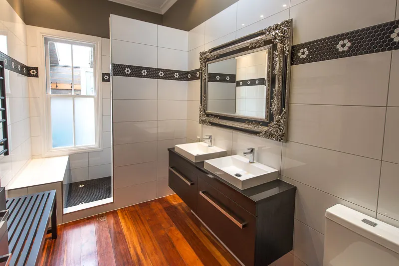 Spacious bathroom with wood floor, double sink vanity and walk-in shower